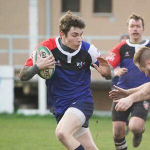 Rugbyspieler Simon Grasbon von Stade Sarrois Rugby Saarbrücken weicht Tackle von Gegenspieler aus.